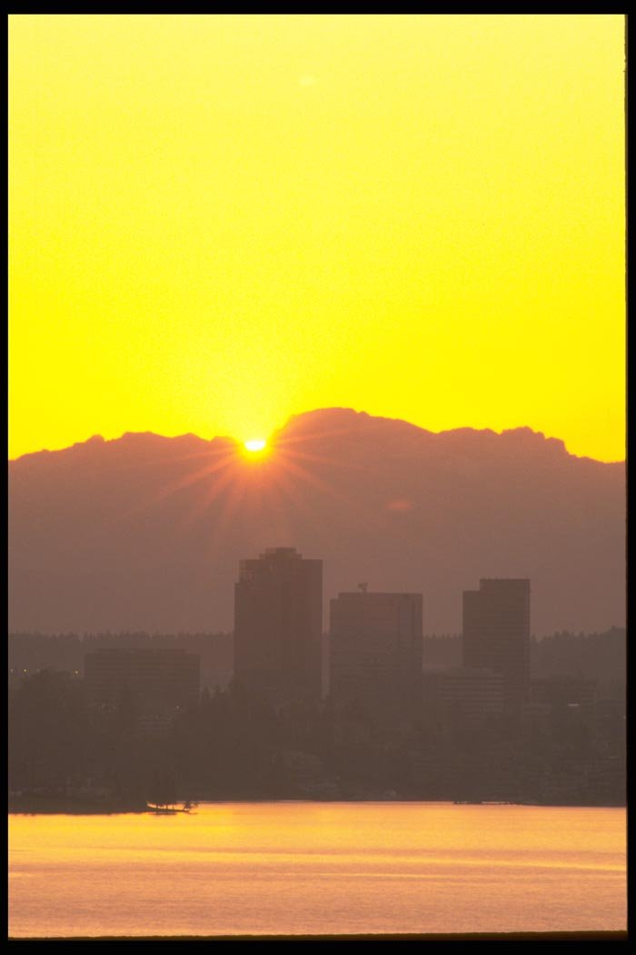 001047 Yellow Sun Peeking Behind Clouds Over City A4 Photo Print