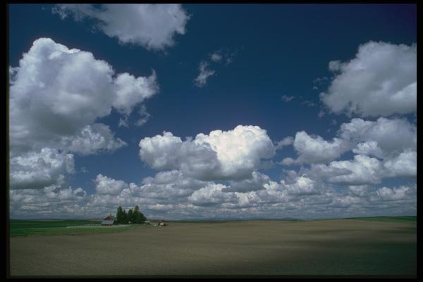 028088 Farm Land Under Fluffy Clouds A4 Photo Print