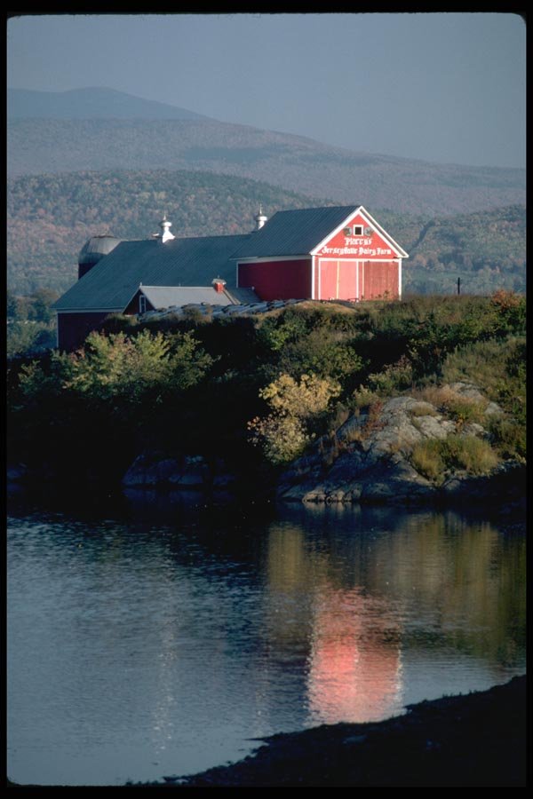 097046 Red Dairy Barn Beside Water A4 Photo Print