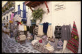 118039 Mykonos Shops Display Their Wares Outside As Well As In A4 Photo Print