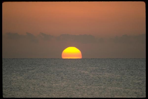 178005 Distant Sun Setting Behind Ocean A4 Photo Print