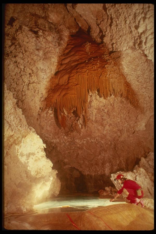 194057 Dipping From A Pool Beneath Orange Flowstone, Lechuguilla A4 Photo Print