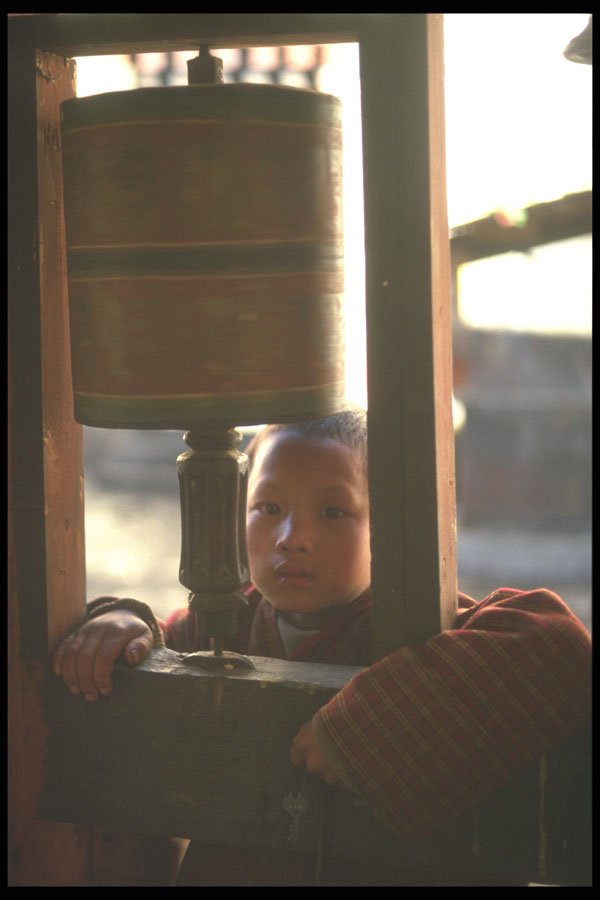 246079 Boy behind prayer wheel, Tongsa Dzong A4 Photo Print