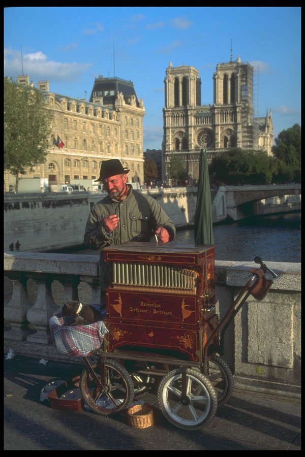 281024 Organ Grinder On The Seine A4 Photo Print