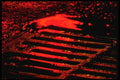 313000 Red Neon Light Reflected In Rainwater At Catch Basin A4 Photo Print