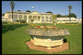 374055 Large Stone Font Filled With Flowers And Main Building A4 Photo Print