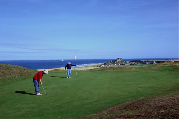 509043 Golfers With Bamburgh Castle And Farne Islands In Background A4 Photo Print
