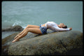 527033 Brunette Lying On Rocks Wearing Cutoff Jeans And Gauze Top A4 Photo Print