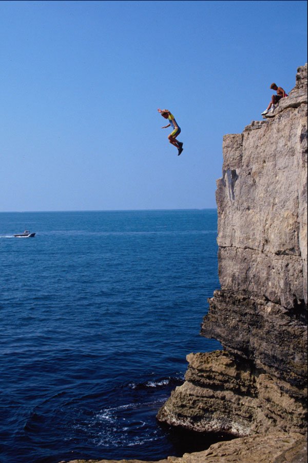 592080 Boy Jumping Into Sea From Pulpit Rock, Dorset, England A4 Photo Print