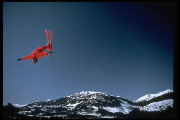 599005 Aerial Skier Performing High Back Somersault Over Mountains A4 Photo Print