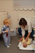 635087 Mother Changing Baby On Floor A4 Photo Print