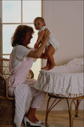 635088 Mother Lifting Baby From Crib A4 Photo Print