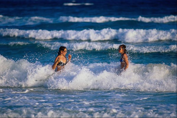 647000 Girls Playing In The Surf A4 Photo Print