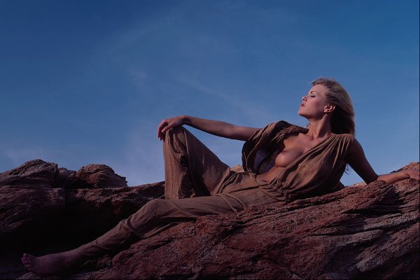 657034 Woman Reclining On Desert Cliff Rocks A4 Photo Print