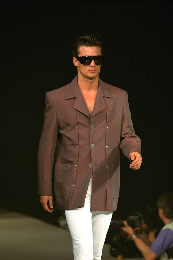 701072 Male In Brown Jacket, White Trousers And Dark Sunglasses A4 Photo Print