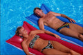 702077 Couple Sunbathing On Air Mattresses In Pool A4 Photo Print