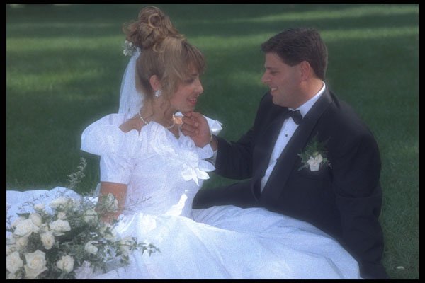 702091 Groom Holding Bride's Face, Sitting On Grass A4 Photo Print