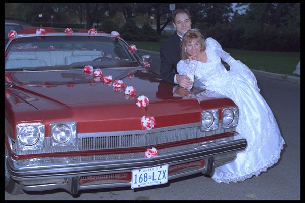 702092 Bride And Groom Leaning On A Convertible A4 Photo Print