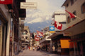714078 Street Scene, Shops, Flags, Distant Peaks, Engelberg A4 Photo Print