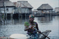 783034 Woman Rowing Around From House To House Selling Goods A4 Photo Print