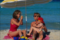 784018 Family Taking Photographs On Beach, Under Umbrella A4 Photo Print